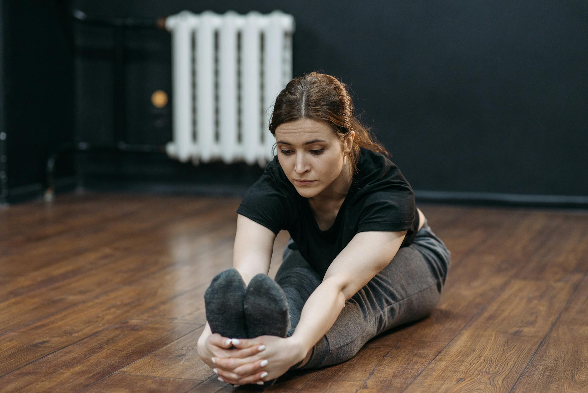 a woman doing a seated leg stretch